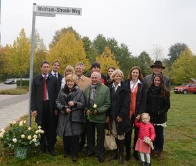 Unterschleißheims Erster Bürgermeister Christoph Böck und die Familie Stronk unter dem neuen Straßenschild